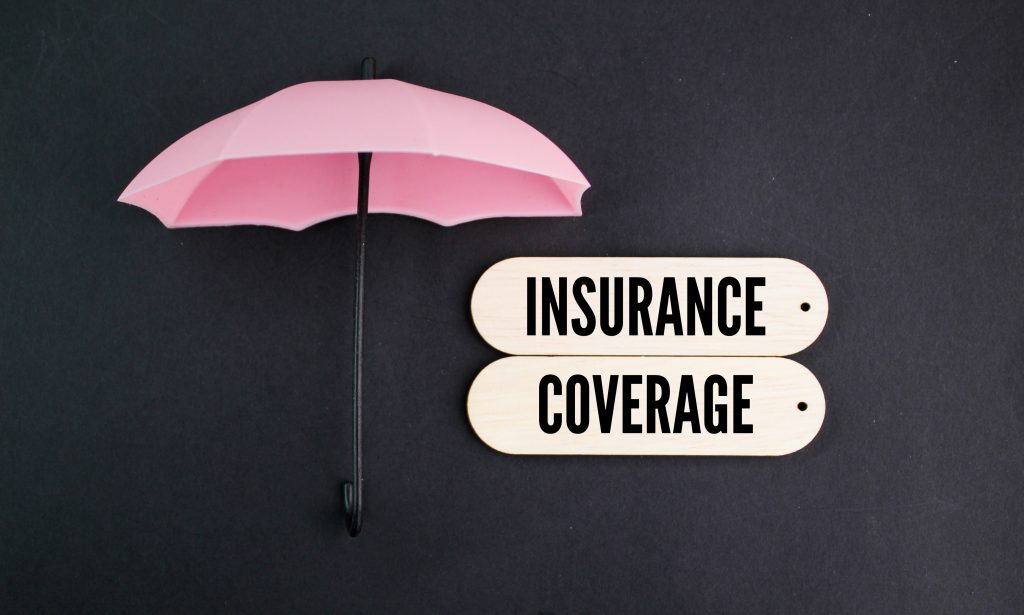 umbrella and board with the word Insurance coverage.